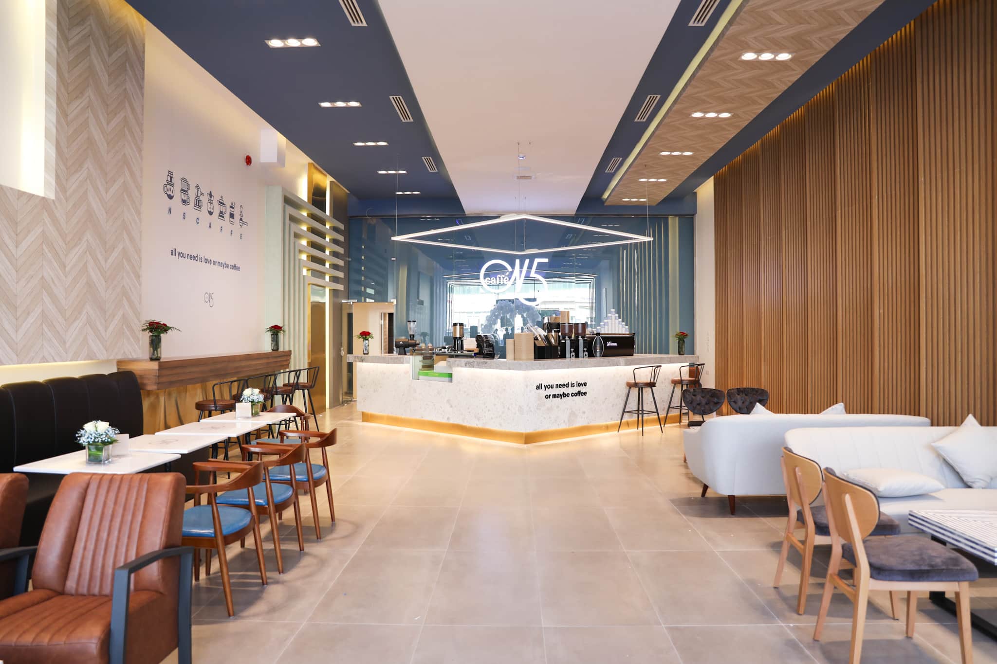 Modern cafe with mixed seating layout, booths, communal counter and lounge seating