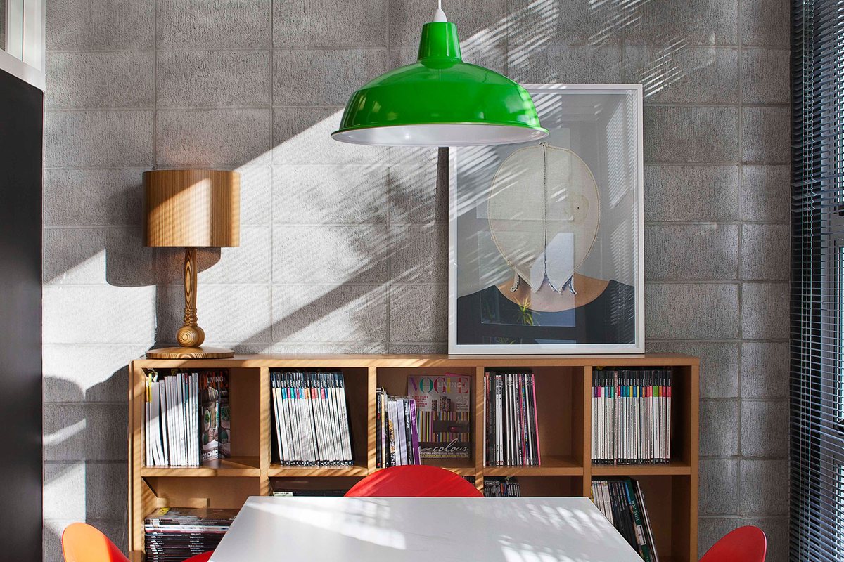 Office Layout Ideas: How to Plan a Better Workplace 2 Office meeting table with orange chairs, a green pendant light and timber bookshelves