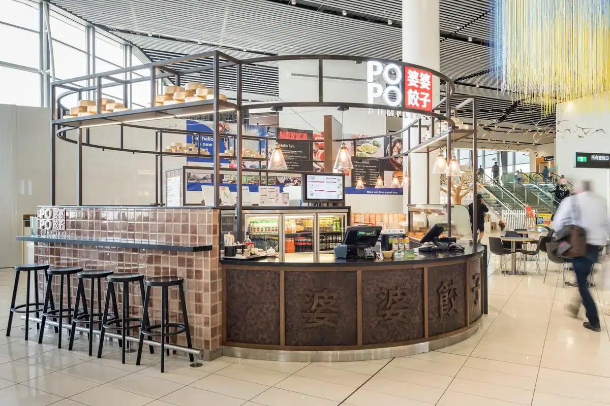 Restaurant Interior Design: Ideas From Real NZ Projects 3 Popo Dumplings kiosk at Auckland Airport with a curved copper and tile counter and bar stools along one side