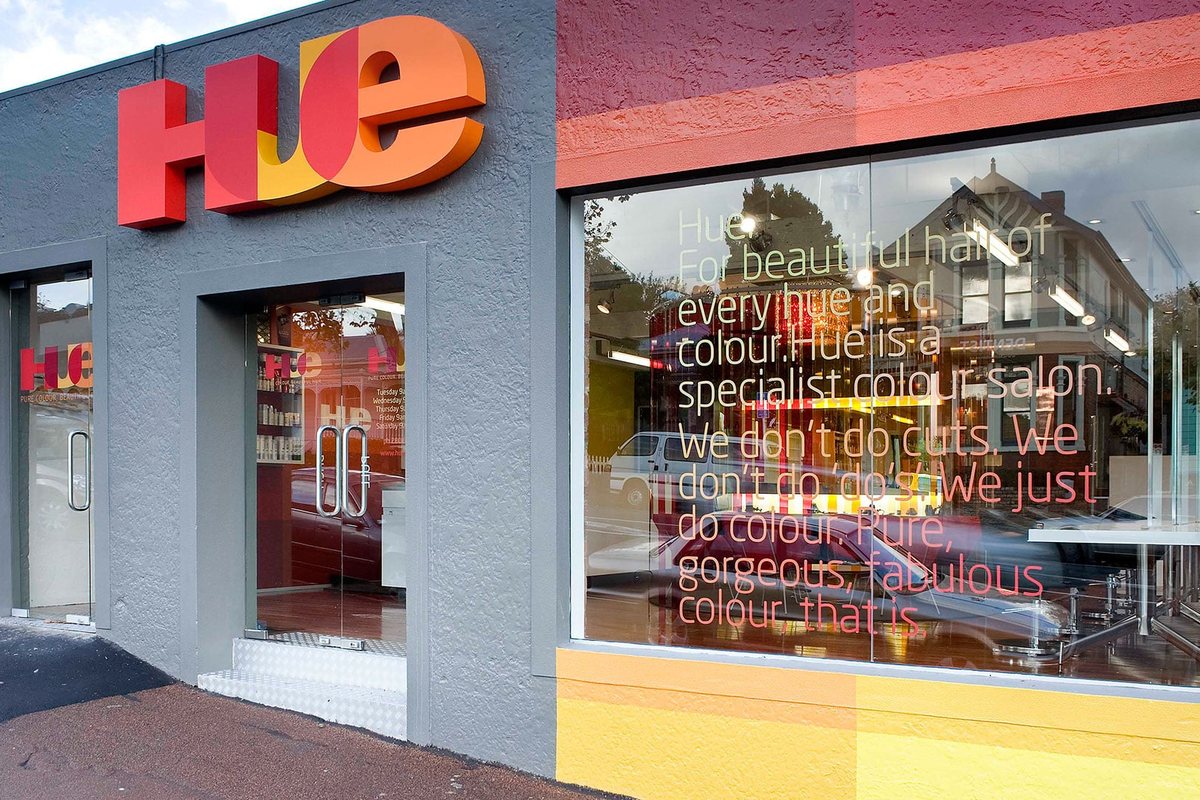 Salon Interior Design: Layout Ideas for Hair Salons 3 HUE salon shopfront with large orange lettering and window graphics