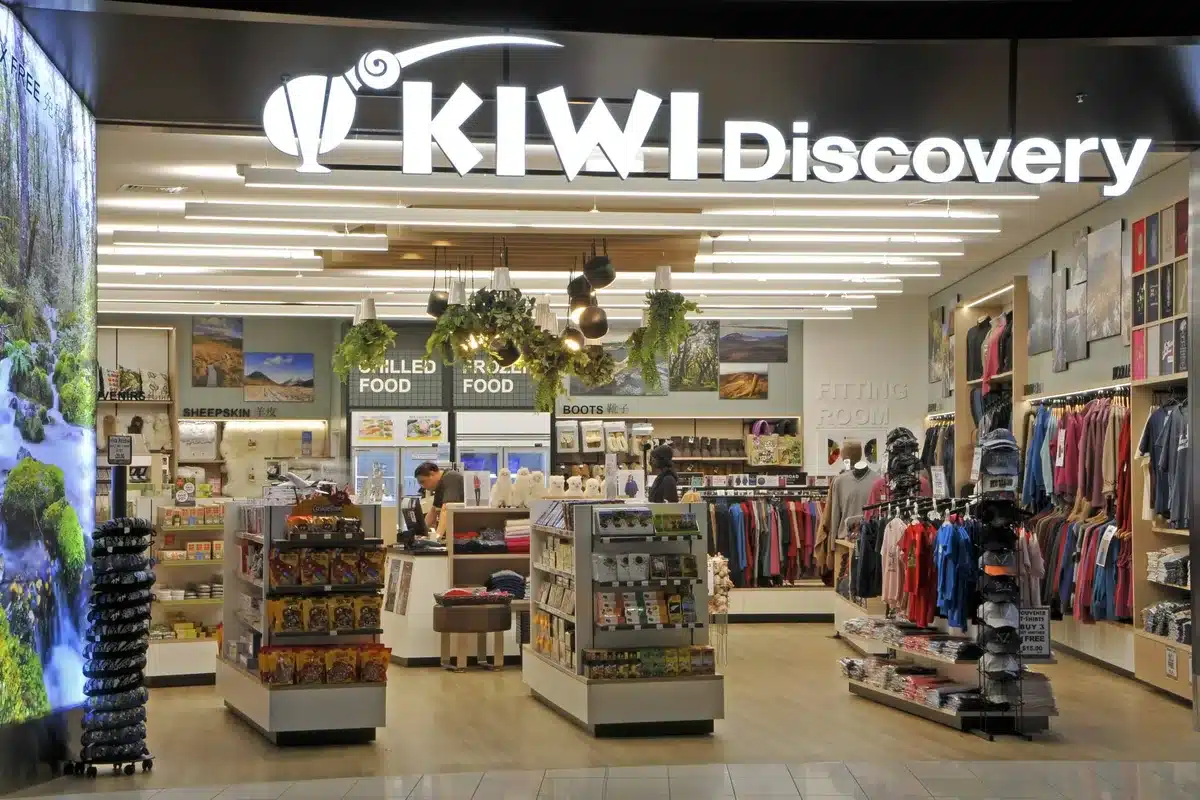 Visual Merchandising: Ideas From Real NZ Stores 3 Kiwi Discovery shop at Auckland Airport with white and timber racking, category signs and hanging plants